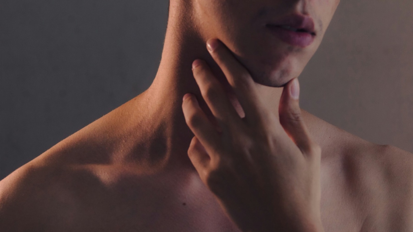 Close view of a person’s neck and collarbone in warm side light
